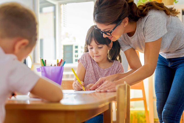 A teacher complimenting her student on her coloring.