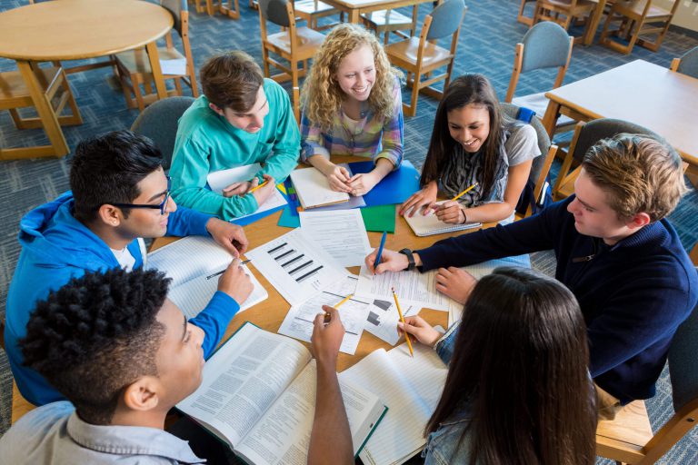 An image of a group of students seated at a circular table in a study group.
