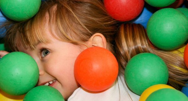 An image of a girl playing in a ball pit.