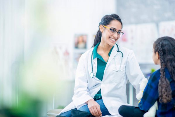 A nurse smiling with her patient in the office.