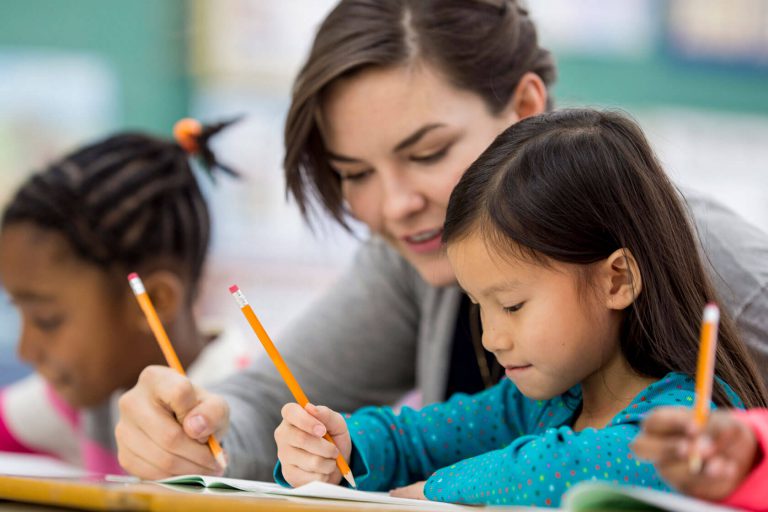 A teacher helping her student solve a written problem.