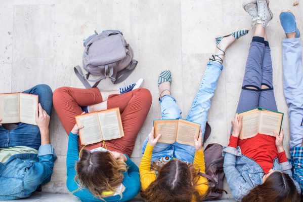 A line of seated students reading different books.