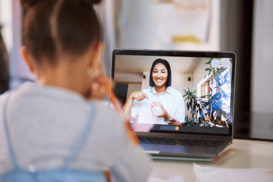 A student seated in front of their laptop during an online teletherapy session.