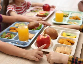 A group of students gathered at a table with full lunch trays.